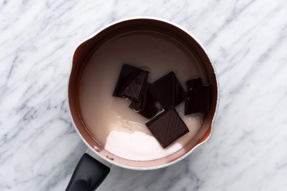 sugar, water, oil, and dark chocolate in a saucepan
