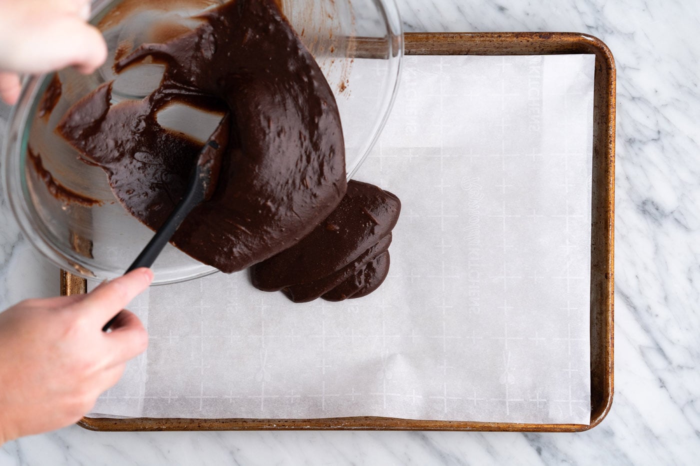 pouring brownie brittle batter into a baking sheet