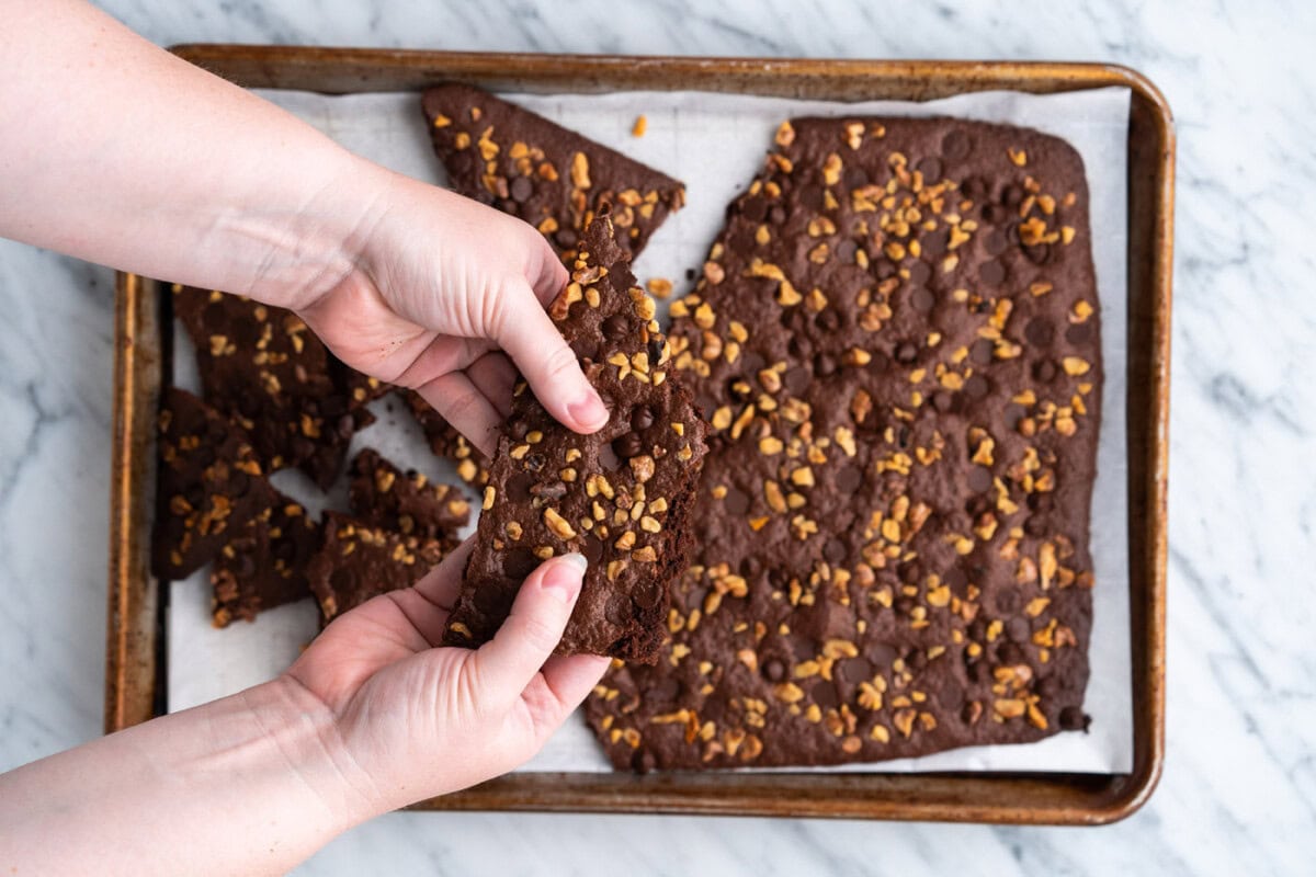 hands breaking apart brownie brittle