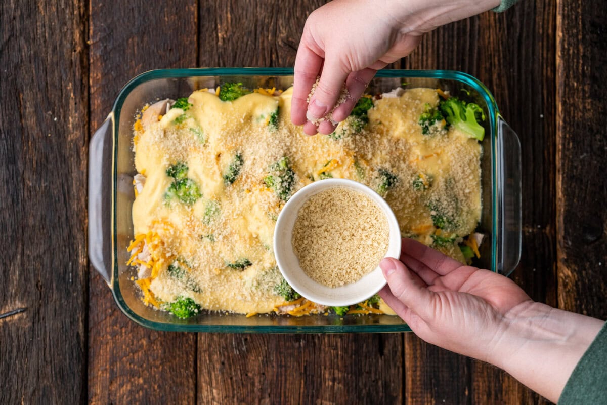 sprinkling breadcrumbs over chicken divan casserole