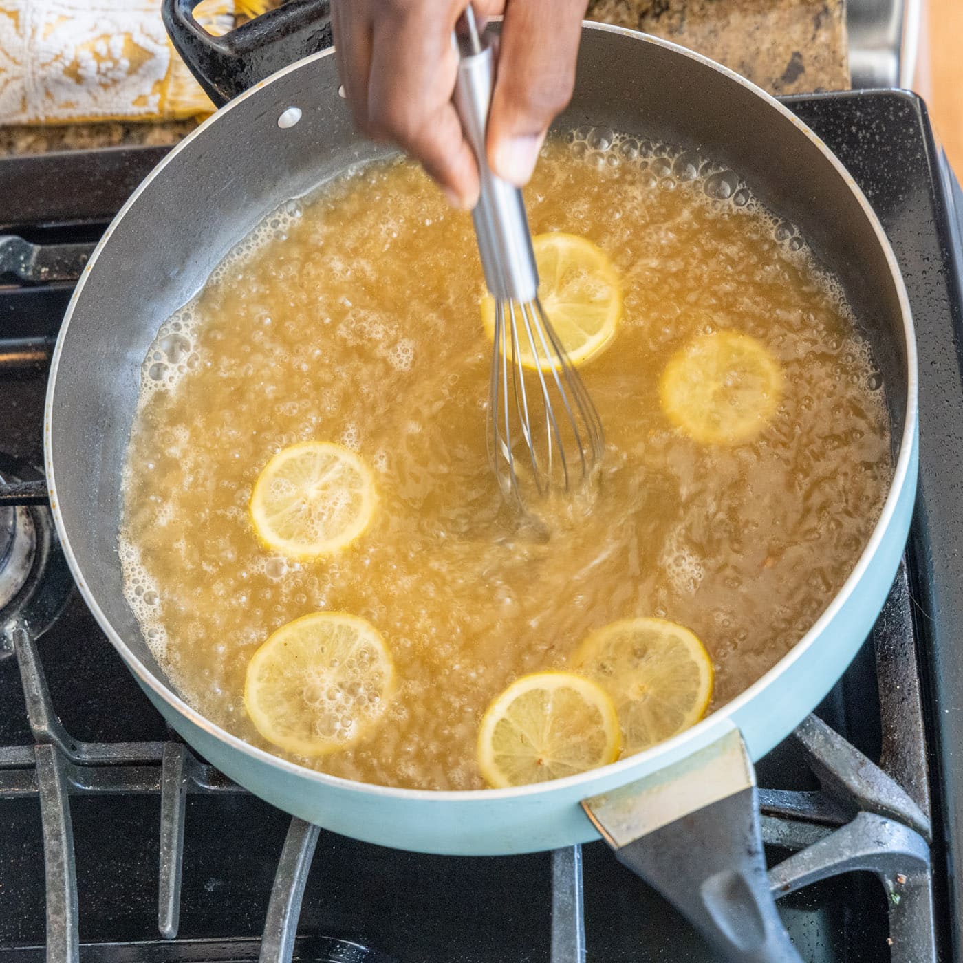 whisking lemon juice with white wine in a skillet
