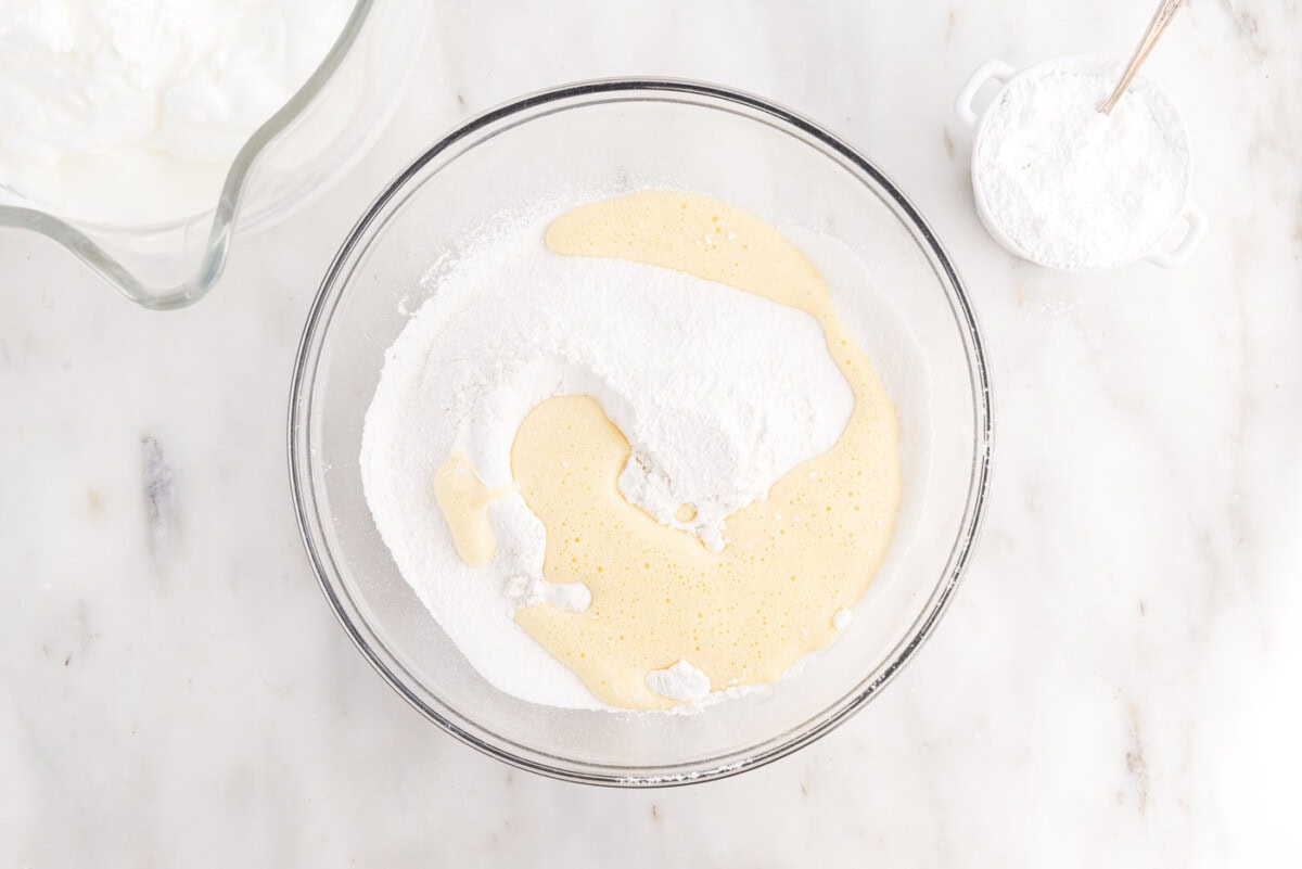 egg yolk mixture added to flour mixture in a bowl
