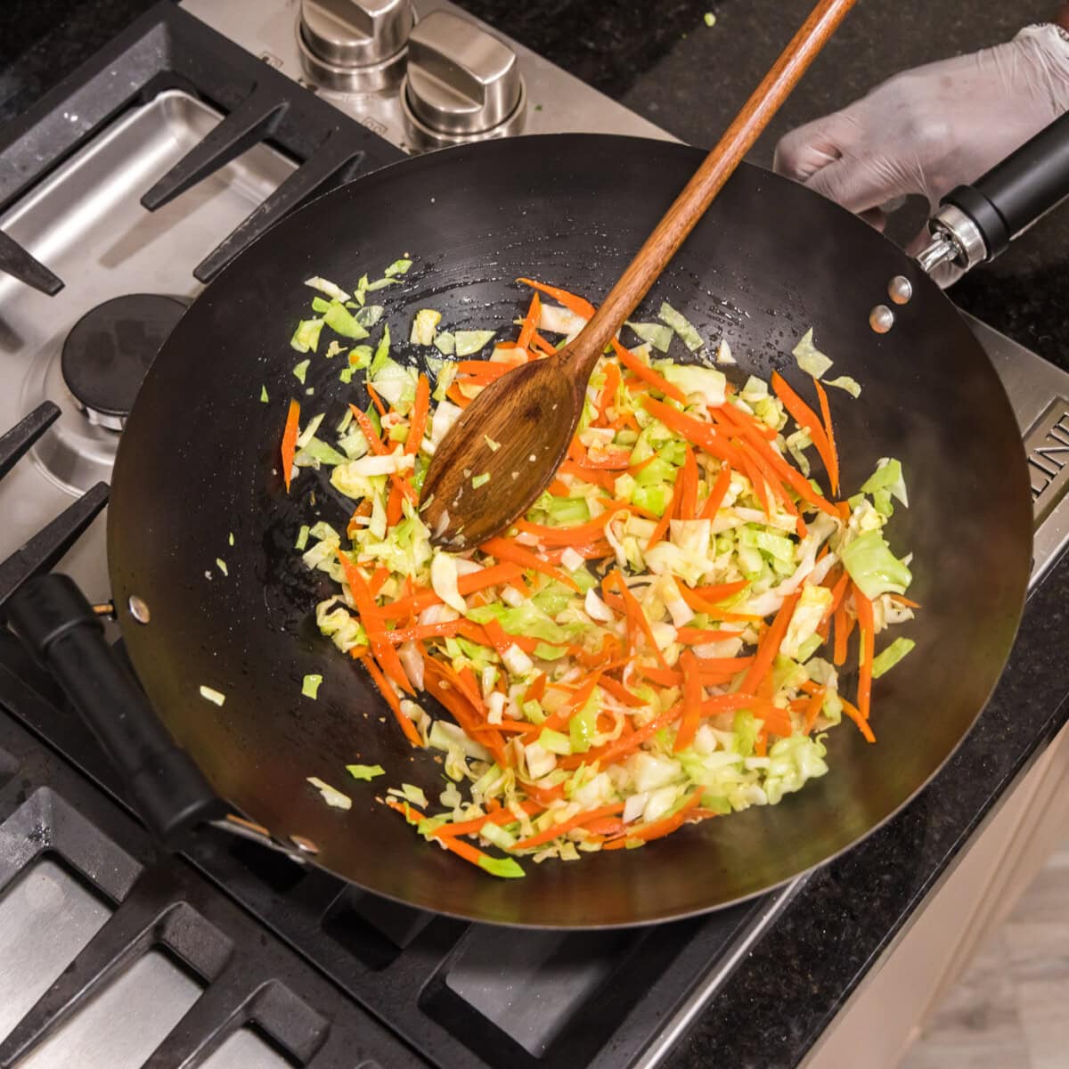 mixing chow mein vegetables in a wok
