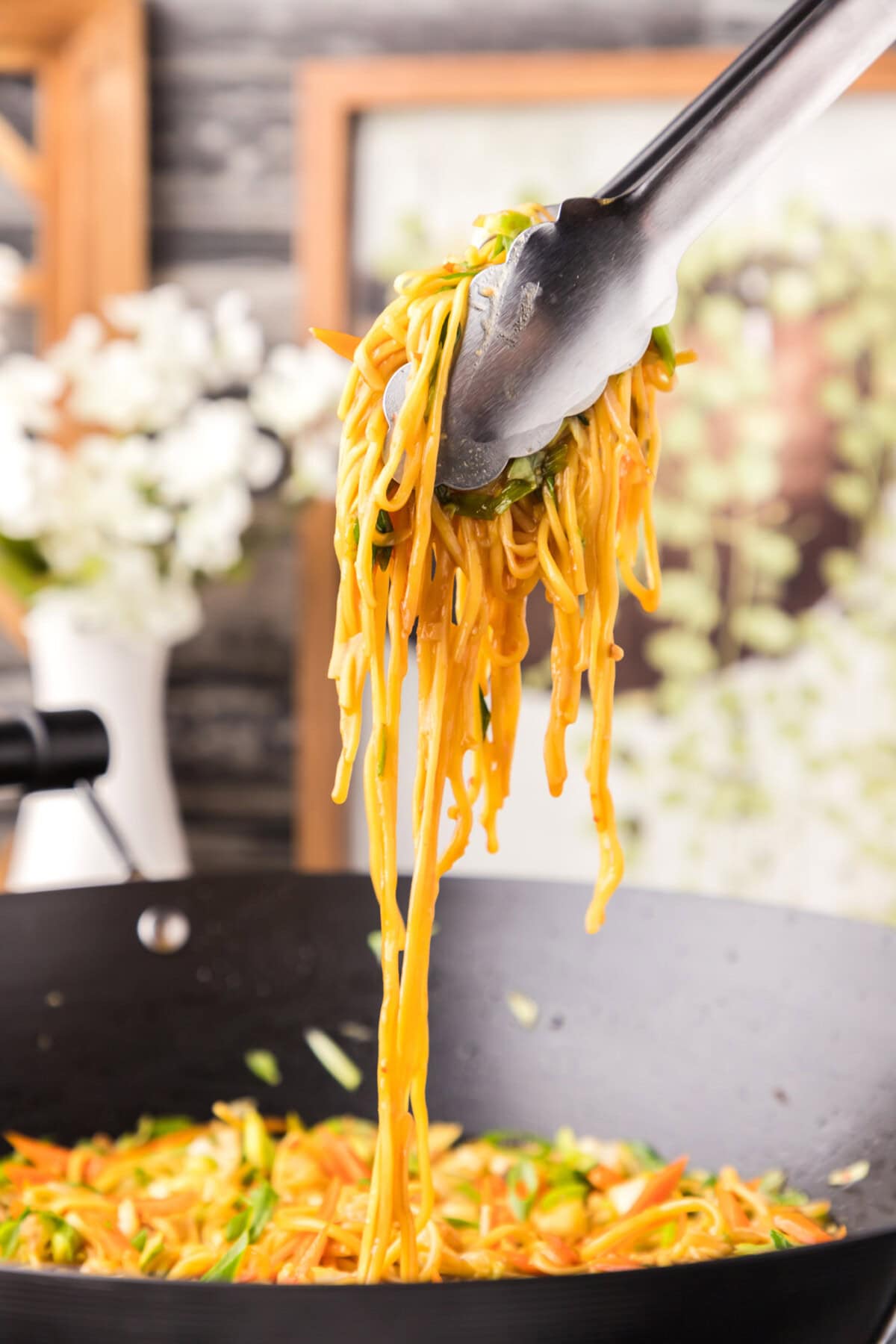 lifting Chow Mein with tongs