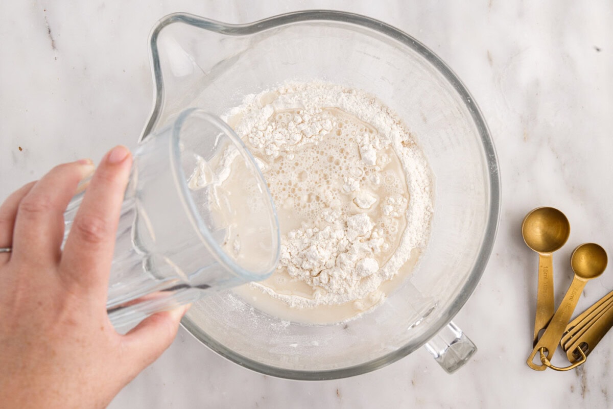 adding water to yeast mixture in bowl