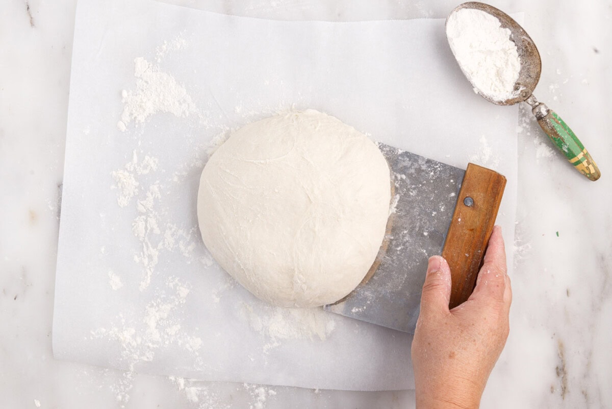 scraping dough with bench scraper