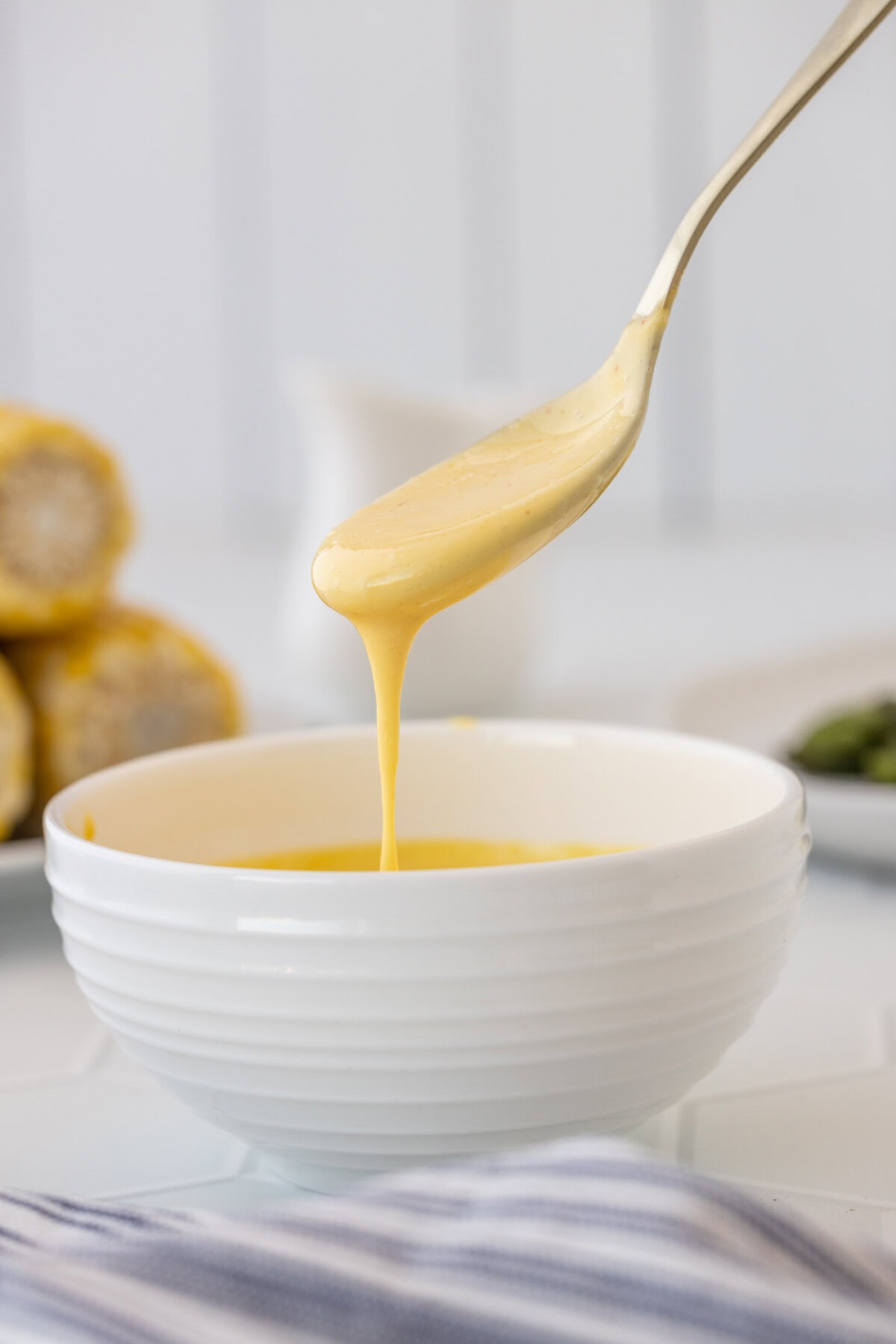 spoon drizzling Hollandaise Sauce