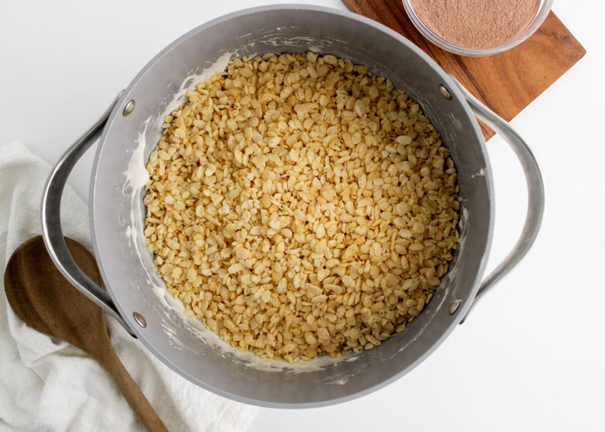 adding rice krispie cereal to marshmallow mixture