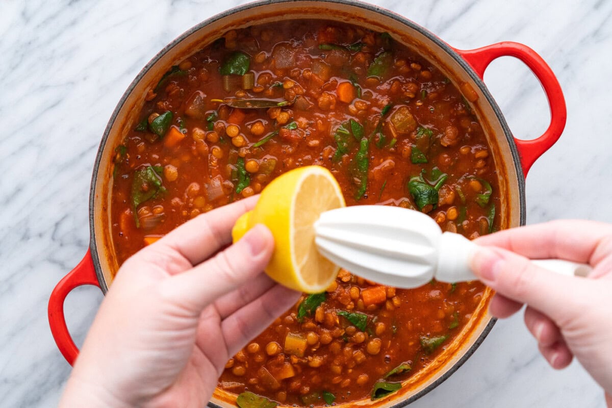 squeezing fresh lemon juice over lentil soup
