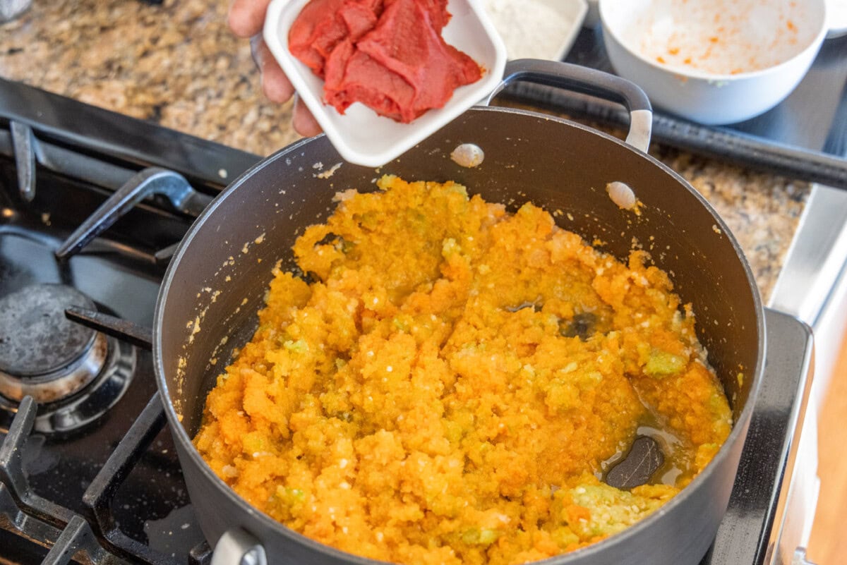 adding tomato paste to lobster bisque
