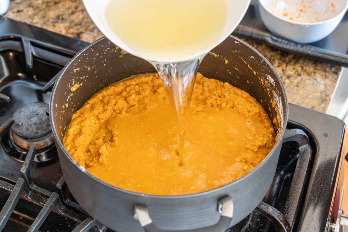 pouring white wine into lobster bisque