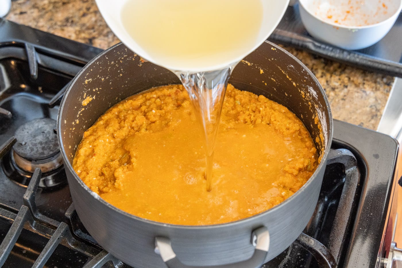 pouring white wine into lobster bisque