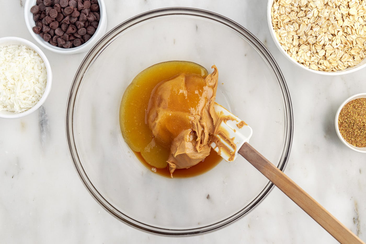 mixing peanut butter, honey, and vanilla in a bowl with a rubber spatula