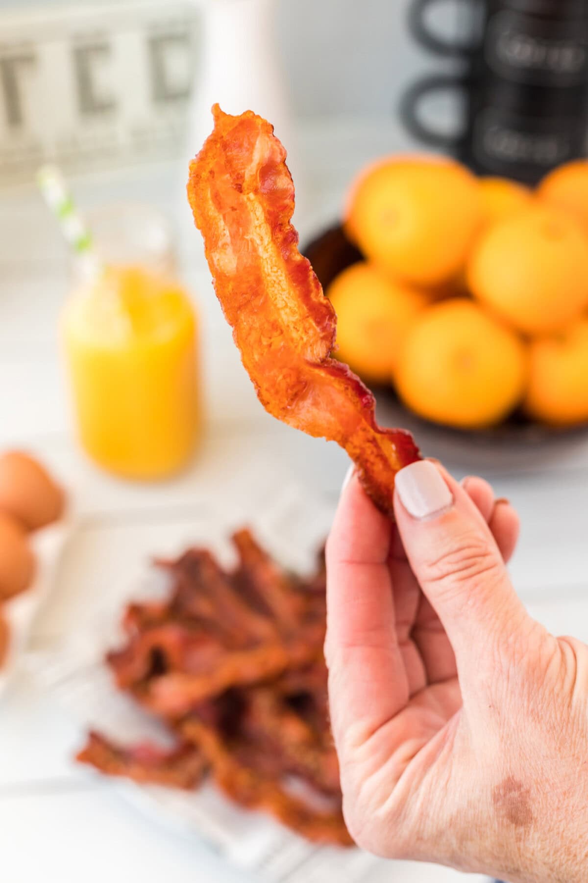 holding a piece of oven bacon