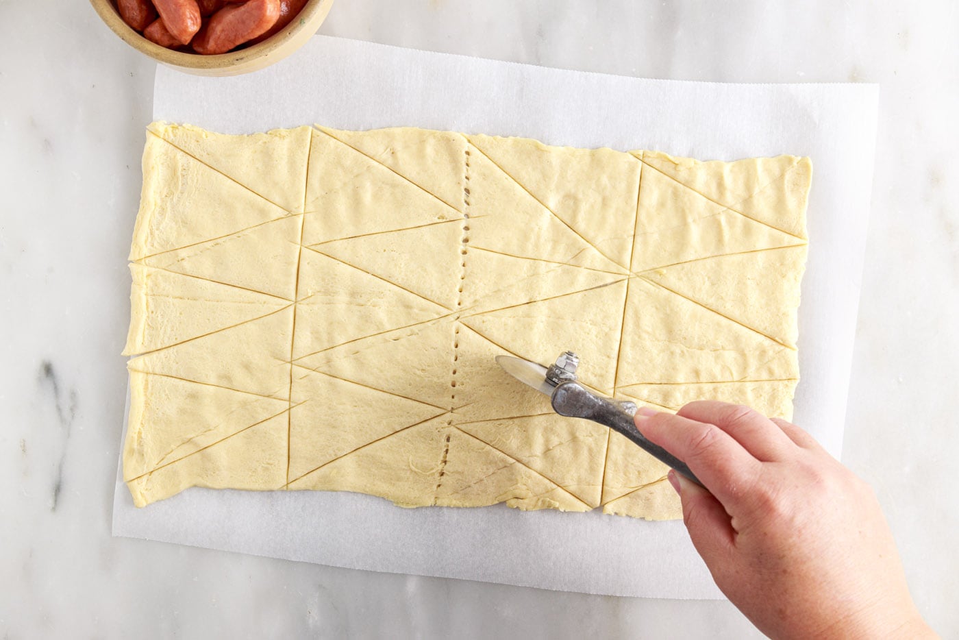 slicing crescent roll dough into triangles