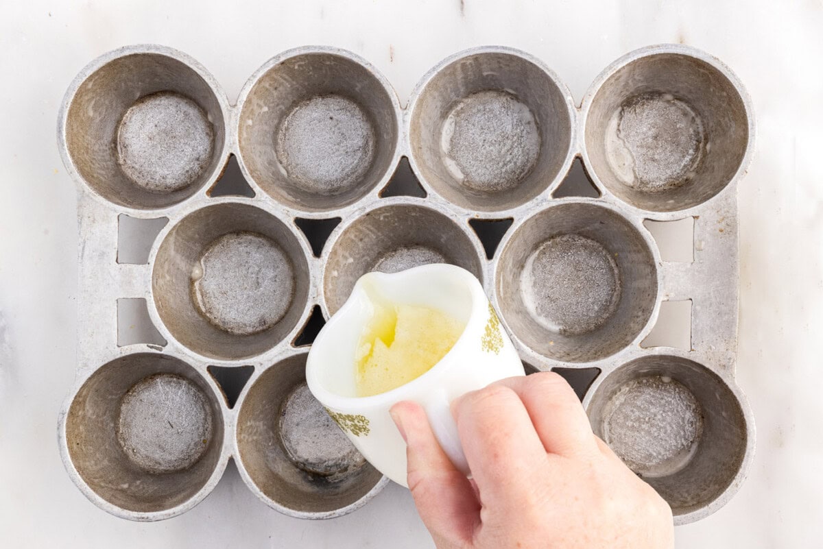 pouring melted butter into warm popover pan