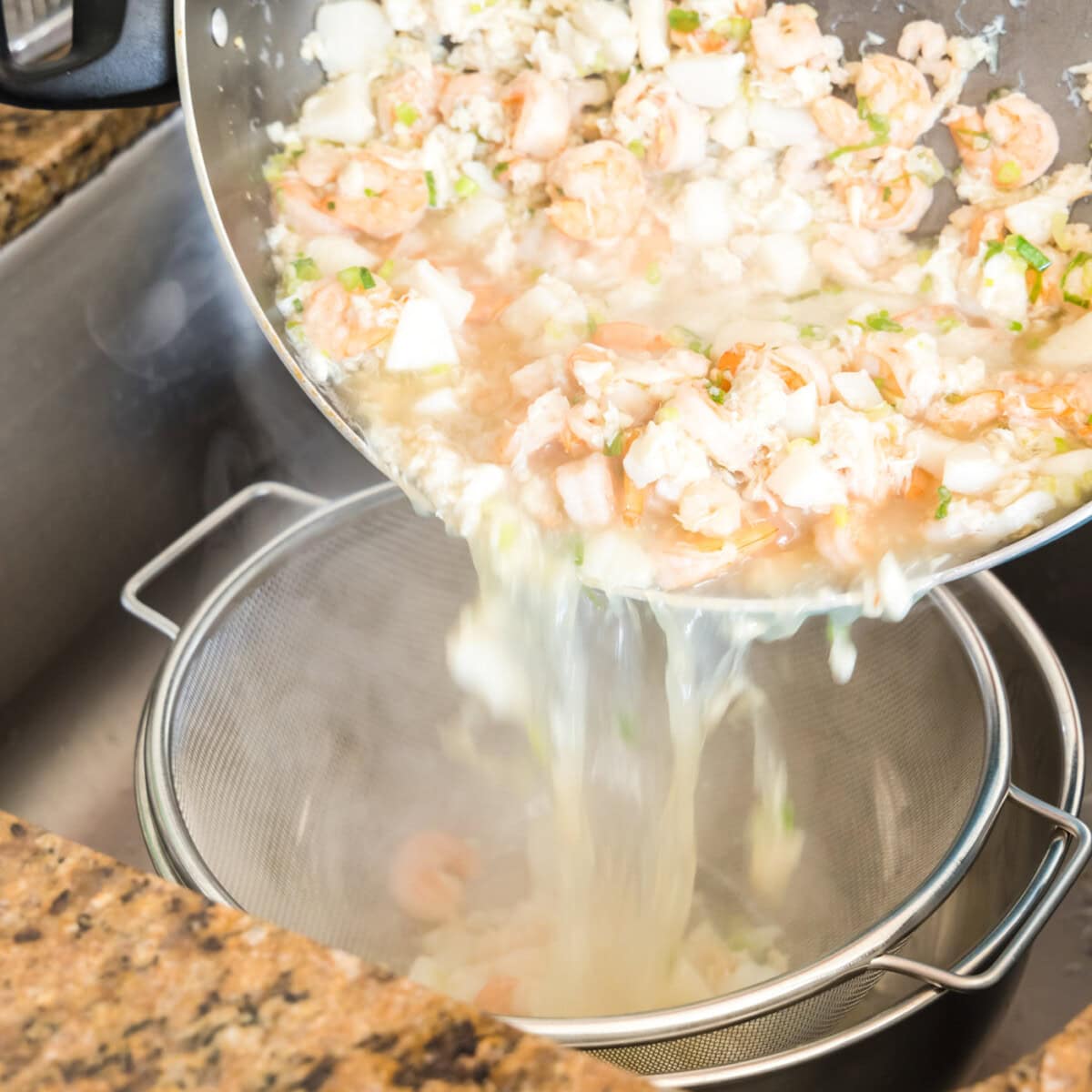 draining seafood lasagna ingredients in a colander