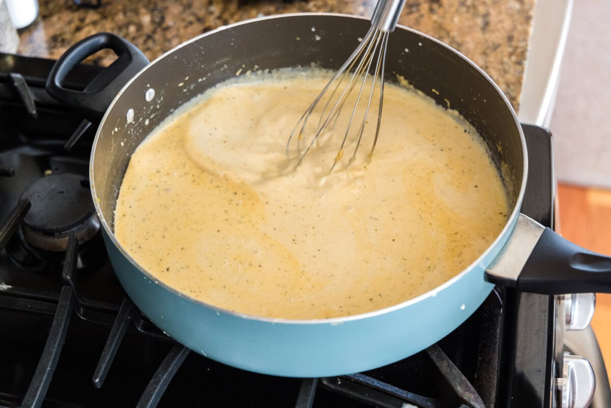 whisking sauce in a saucepan