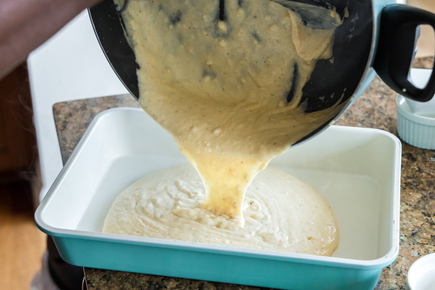 pouring seafood sauce into baking dish