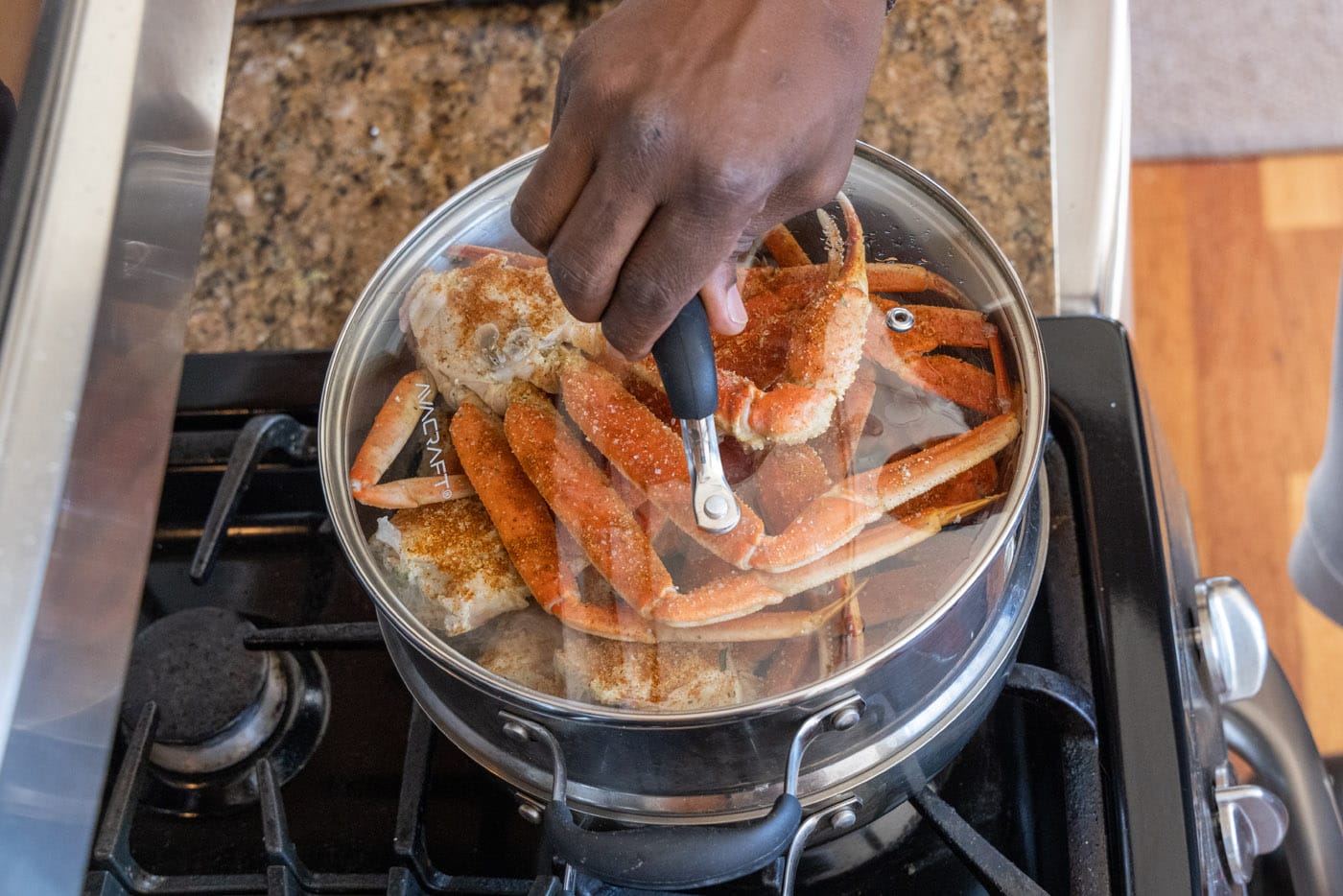 placing lid on steam pot with snow crab legs