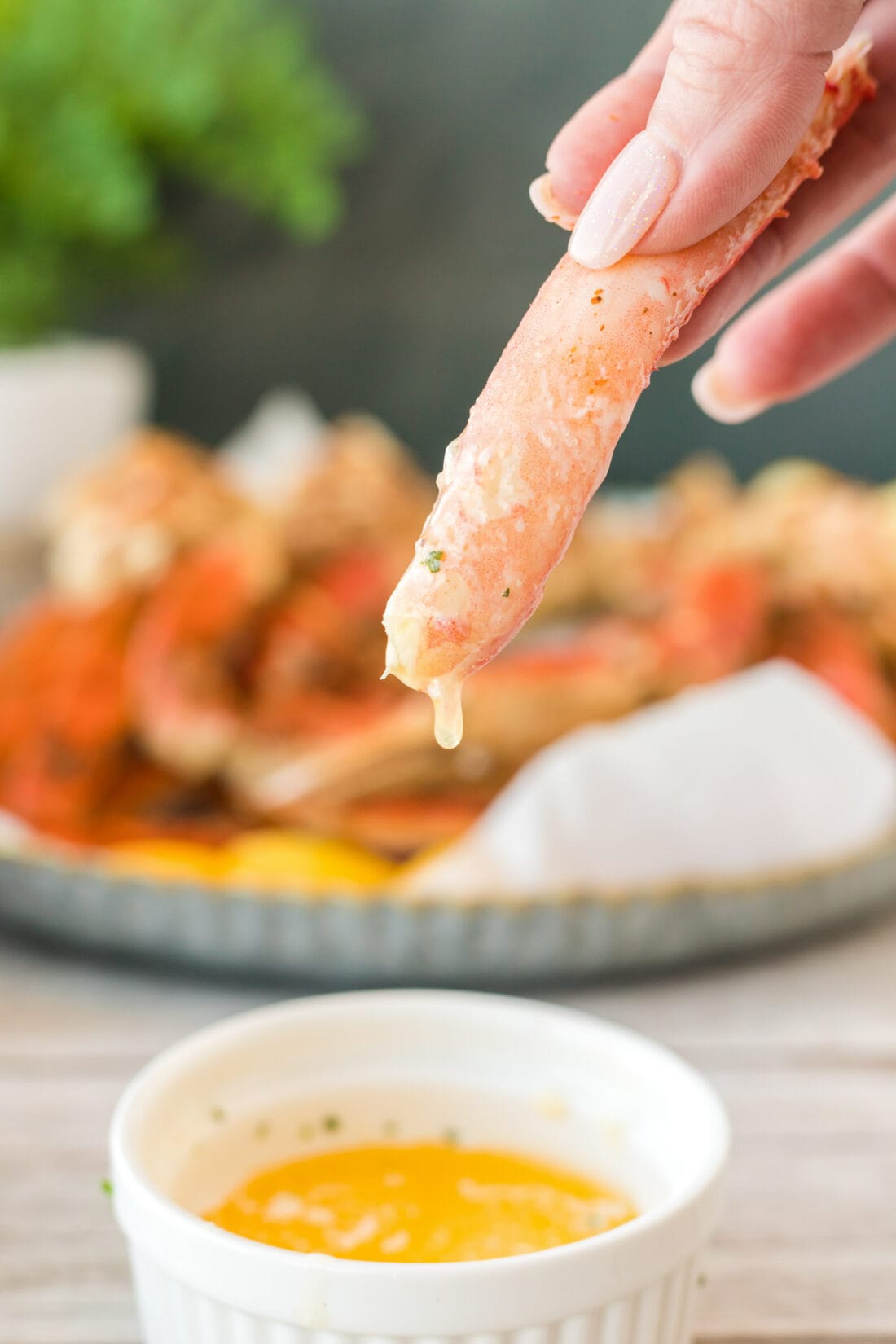 dipping a piece of crab leg into butter
