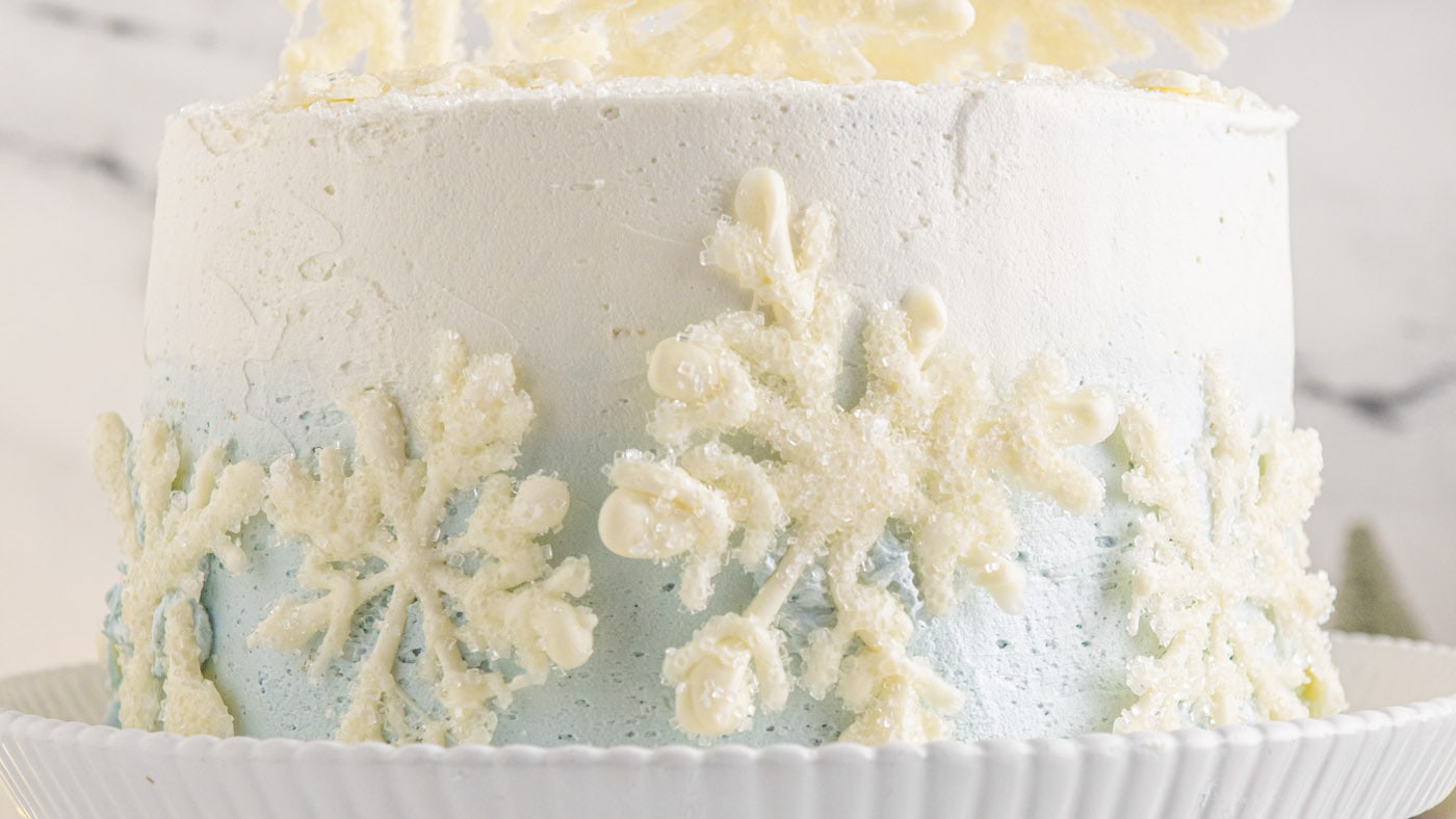 Soft and bouncy homemade white cake is layered with baby blue and white buttercream frosting in this
