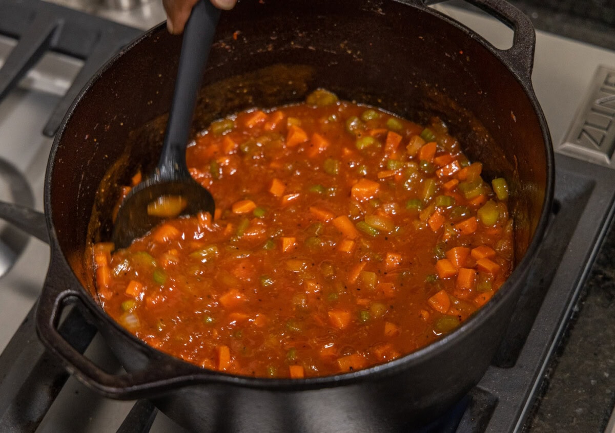 stirring veal osso buco in dutch oven