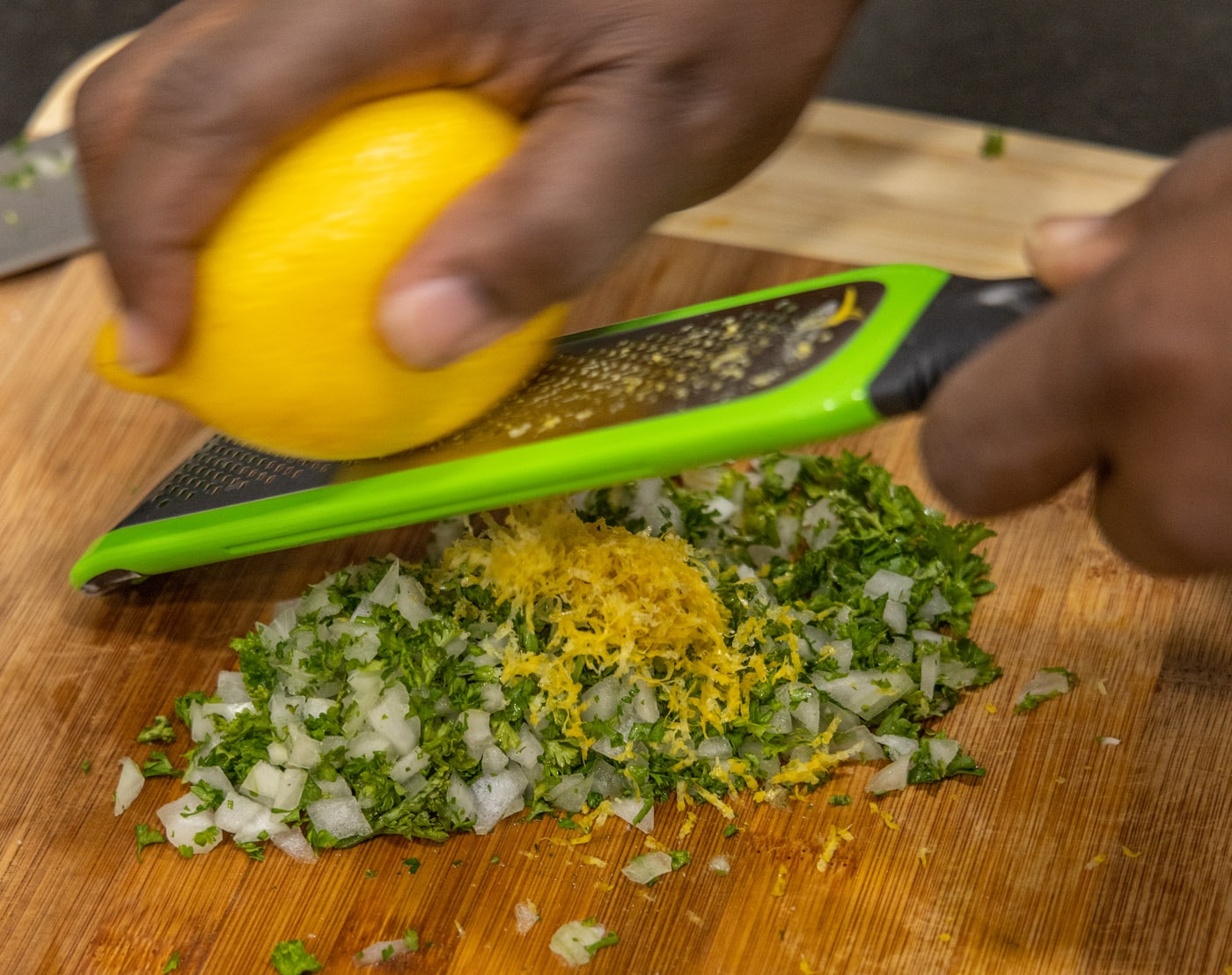 grating lemon over onion and parsley