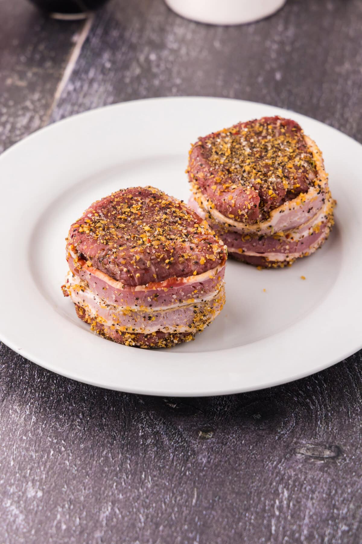 bacon wrapped around filet mignon on a plate
