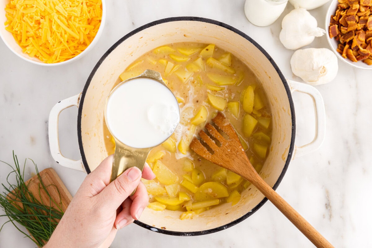 pouring milk into potato soup