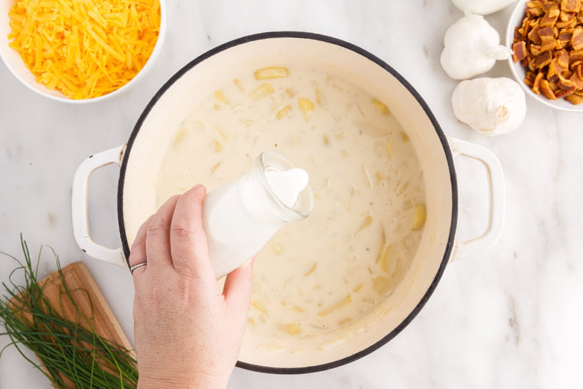 pouring heavy cream into baked potato soup