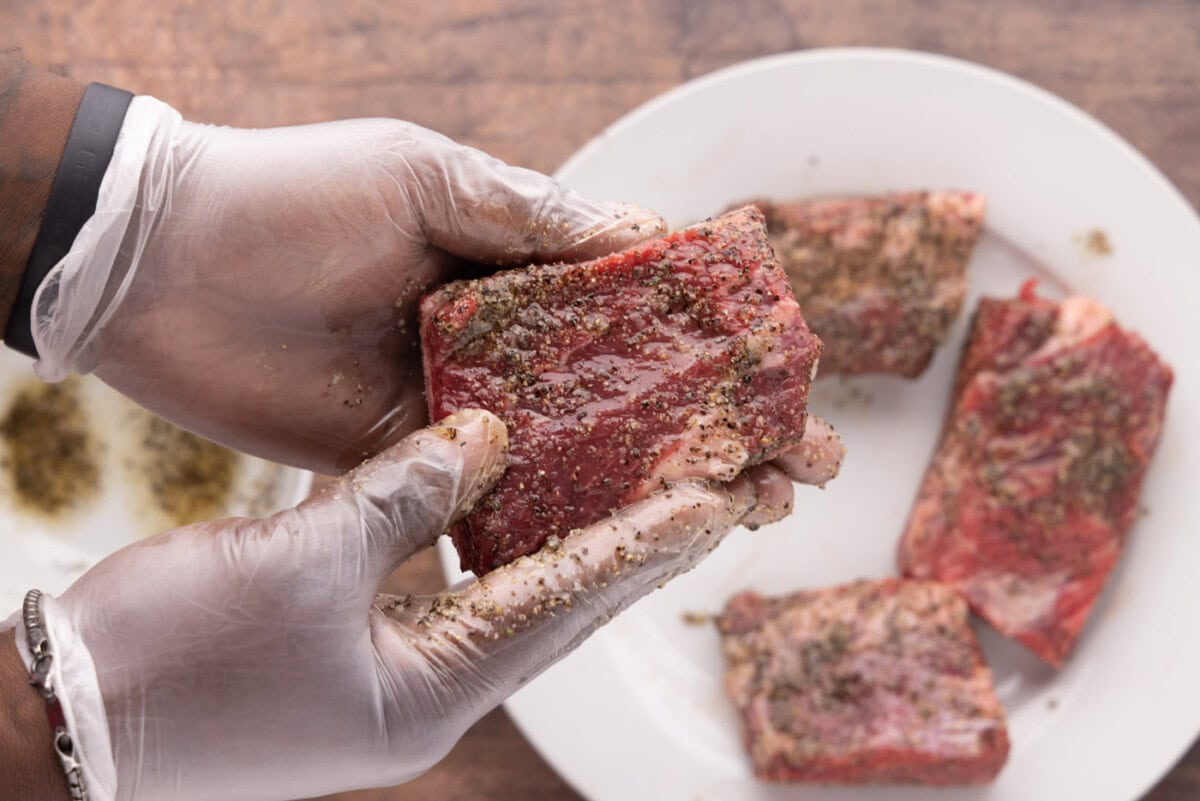 rubbing pepper and garlic salt on beef short ribs