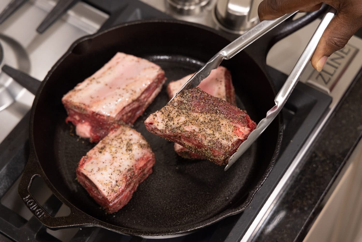 searing beef short ribs in a skillet