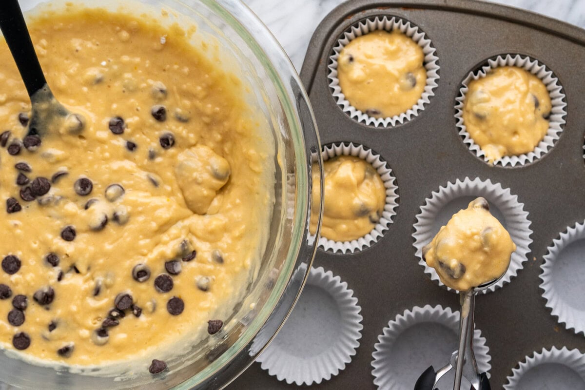 adding batter to muffin pan with liners