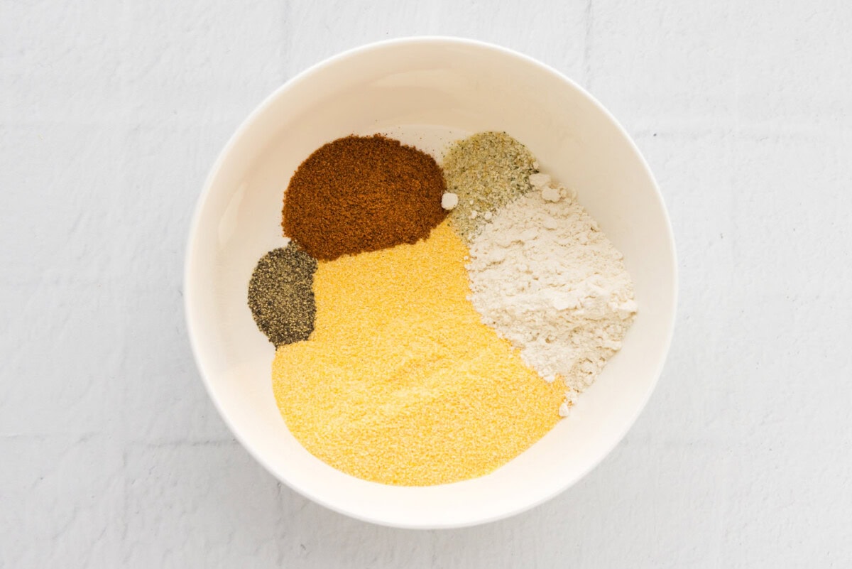 cornmeal, flour, Old Bay, garlic salt, and black pepper in a bowl