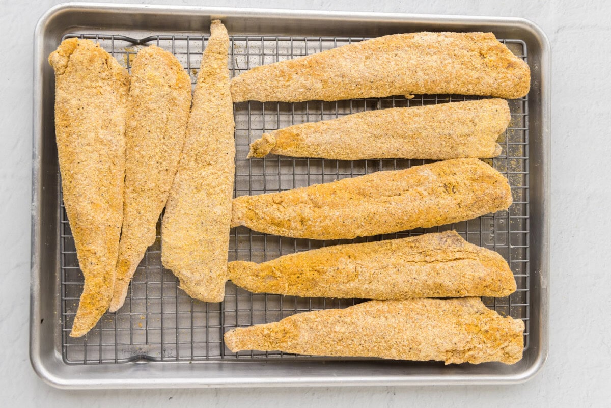 whiting fish in cormeal on a wire rack