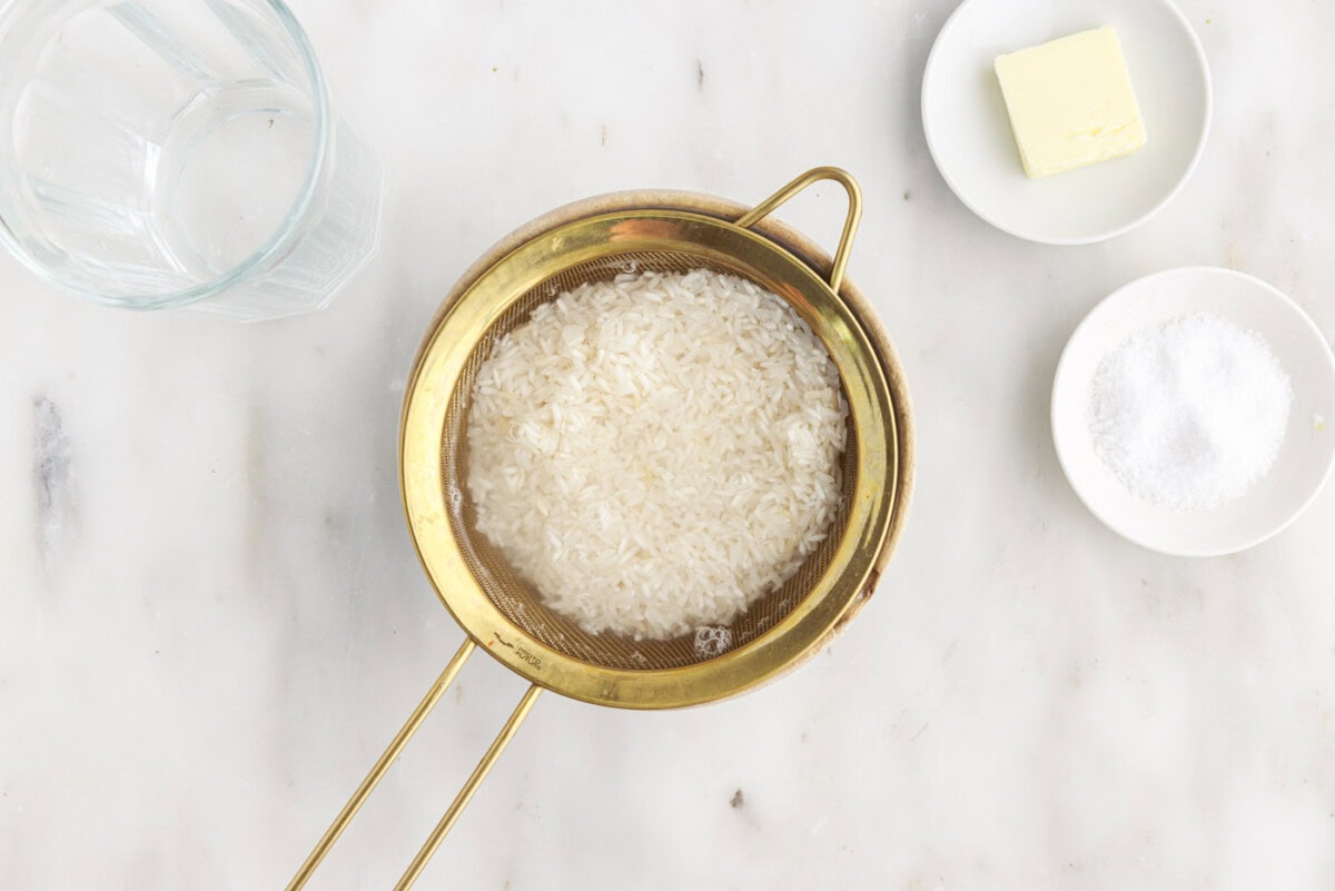 rinsing rice with water in a sieve