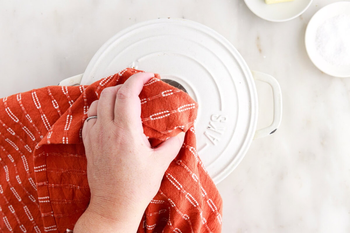 placing lid over rice in a pot