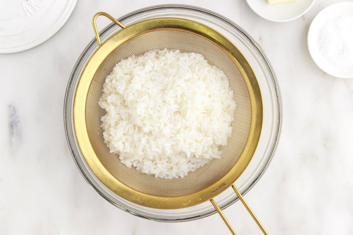 draining cooked rice in a bowl