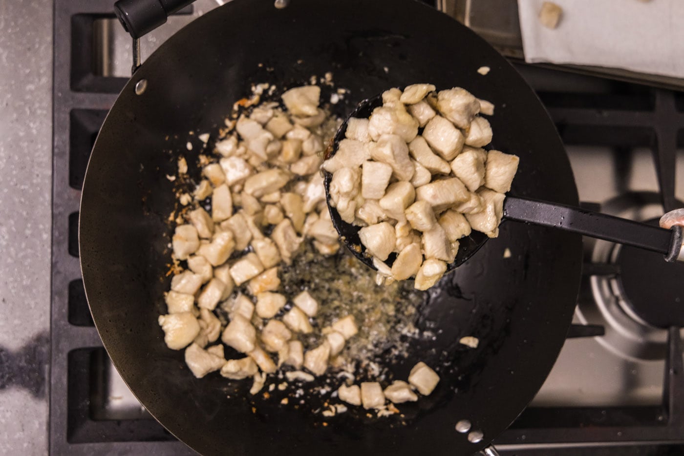 removing chicken pieces from wok