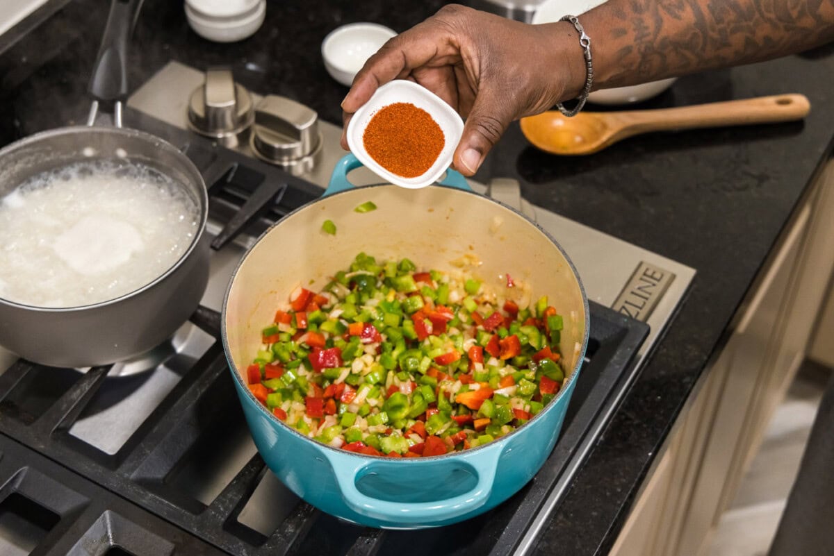 adding smoked paprika to dutch oven with vegetables