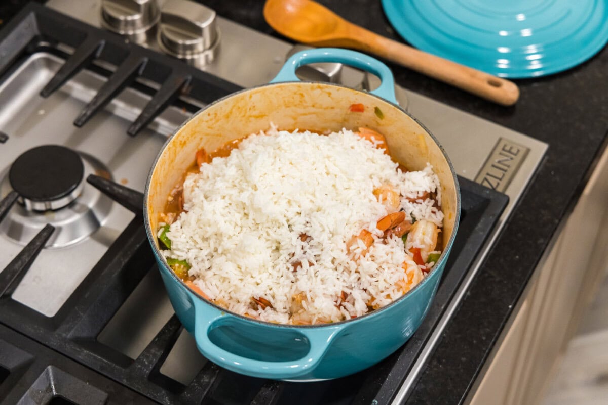 white rice on top of jambalaya in a dutch oven