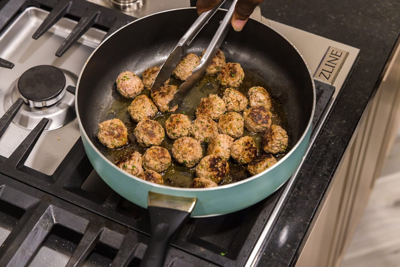 turning meatballs in a skillet