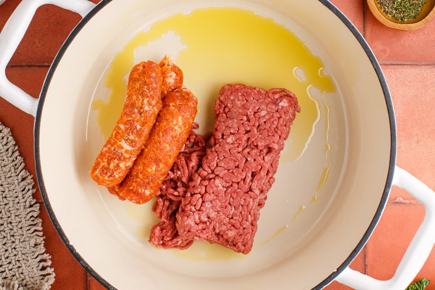 sausage and ground beef in a pot with oil