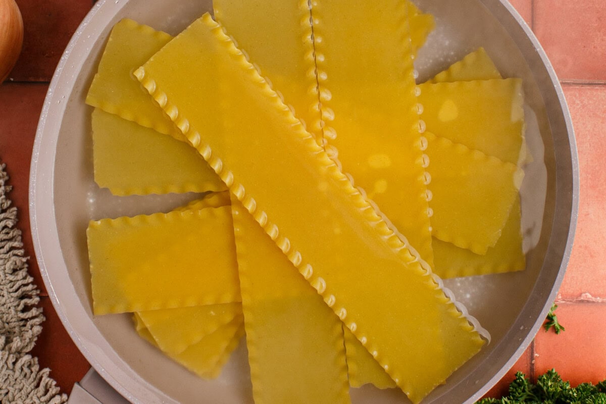 soaking lasagna noodles in a pot to soften