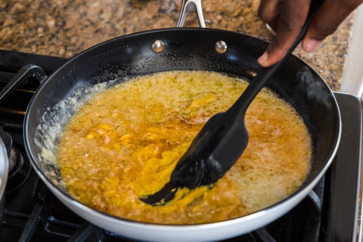 mixing lobster thermidor sauce with a spatula