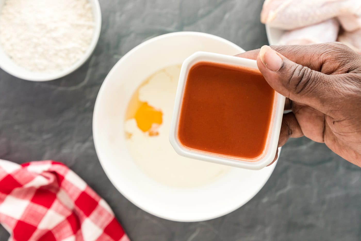 adding hot sauce to cream mixture with spices