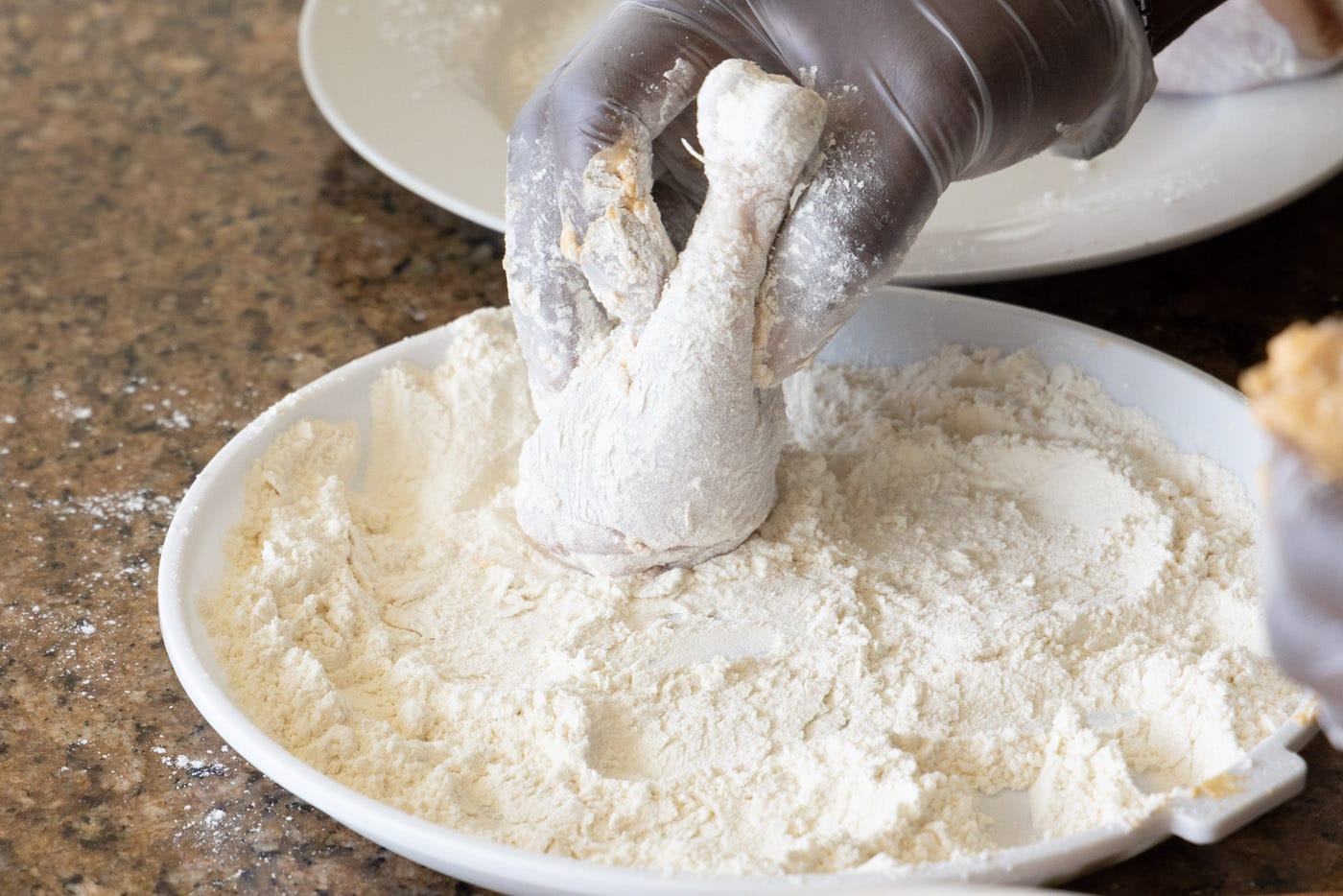 coating chicken legs in flour