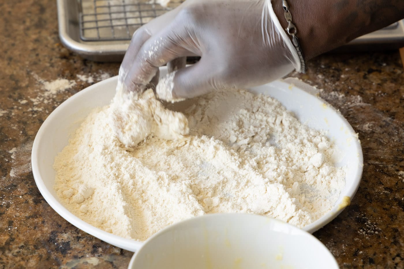 dipping chicken into flour