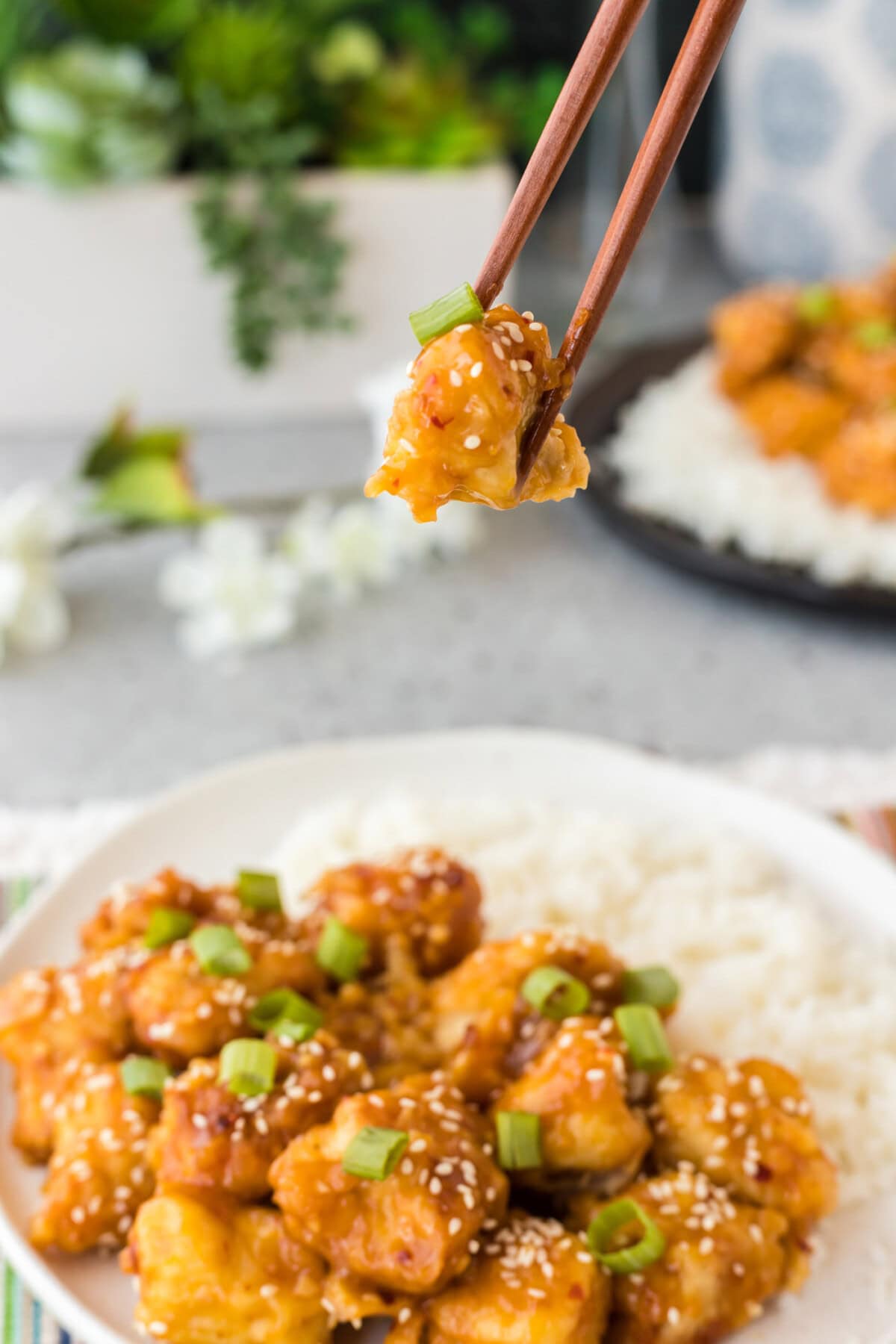 Piece of Orange Chicken in chopsticks